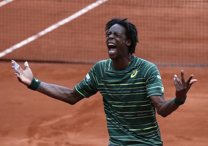 © Reuters. Gael Monfils of France celebrates after beating Pablo Cuevas of Uruguay during their men's singles match at the French Open tennis tournament at the Roland Garros stadium in Paris
