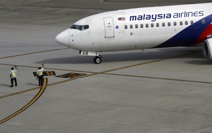 © Reuters. Ground staff wave to a Malaysian Airlines aircraft as it leaves Kuala Lumpur International airport in Sepang outside Kuala Lumpur