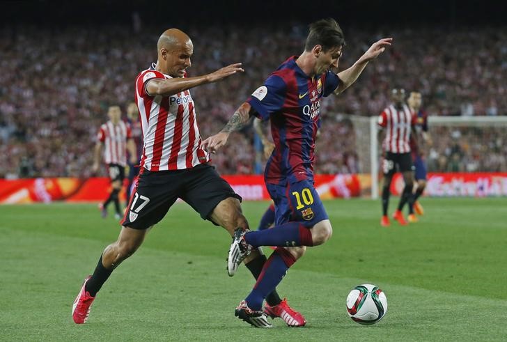 © Reuters. El argentino Lionel Nessi sobrepasa a Mikel Rico del Athletic de Bilbao para anotar el primer gol del Barcelona, ayudando al club azulgrana a obtener la Copa del Rey en el partido del sábado  en el Camp Nou.  30 de mayo, Reuters / Albert Gea