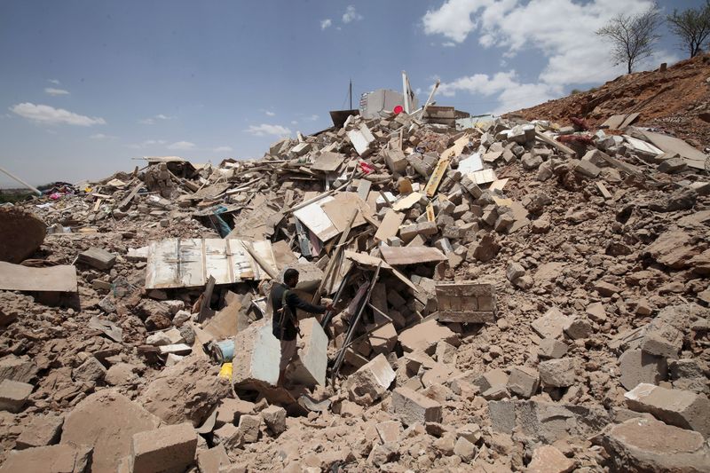 © Reuters. A Houthi militant stands amidst debris from a house of a Houthi leader which was destroyed by a Saudi-led air strike, near Sanaa 