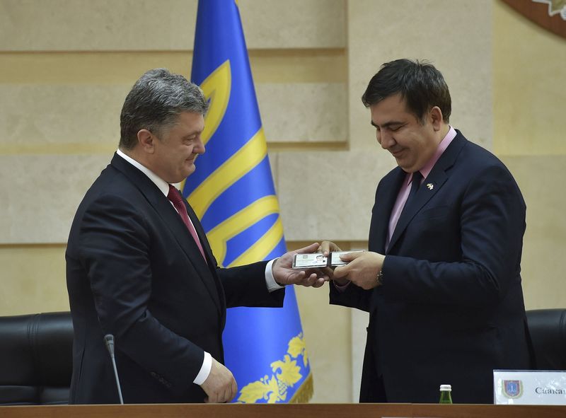 © Reuters. Ukrainian President Poroshenko hands over identification card to Saakashvili as governor of Odessa region during his introduction in Odessa