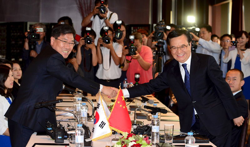 © Reuters. China's Commerce Minister Gao Hucheng shakes hands with South Korea's Trade, Industry and Energy Minister Yoon Sang-Jick during their meeting on a bilateral free trade agreement at a hotel in Seoul