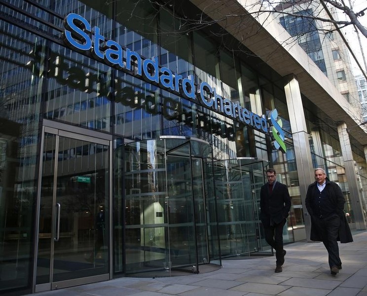 © Reuters. People walk past the head office of Standard Chartered bank in the City of London