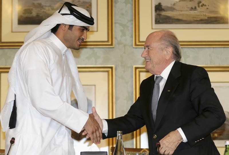 © Reuters. FIFA President Sepp Blatter and Sheikh Mohammed Al-Thani at a news conference in Doha