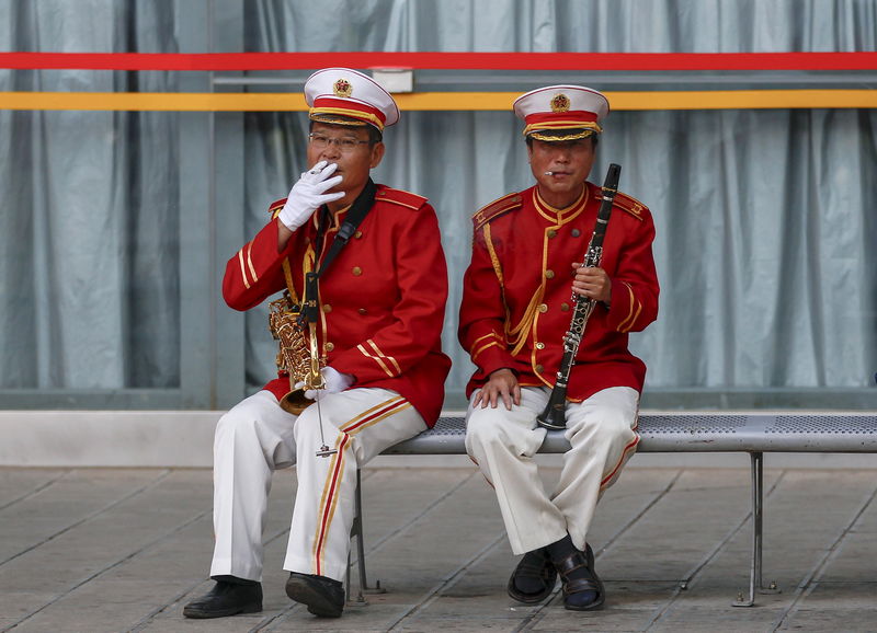 © Reuters. Membros de conjunto musical fumando durante o intervalo, na China