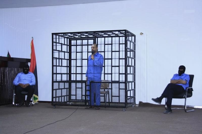 © Reuters. Saif al-Islam Gaddafi, son of late Libyan leader Muammar Gaddafi, attends hearing behind bars in a courtroom in Zintan