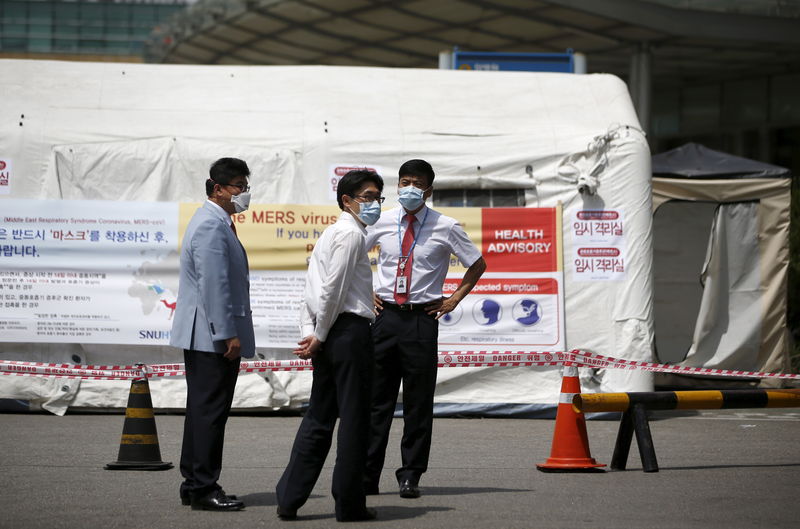 © Reuters. Hospital workers stand in front of a quarantine area set up at a hospital in Seoul