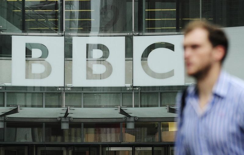 © Reuters.  A pedestrian walks past a BBC logo at Broadcasting House in central London