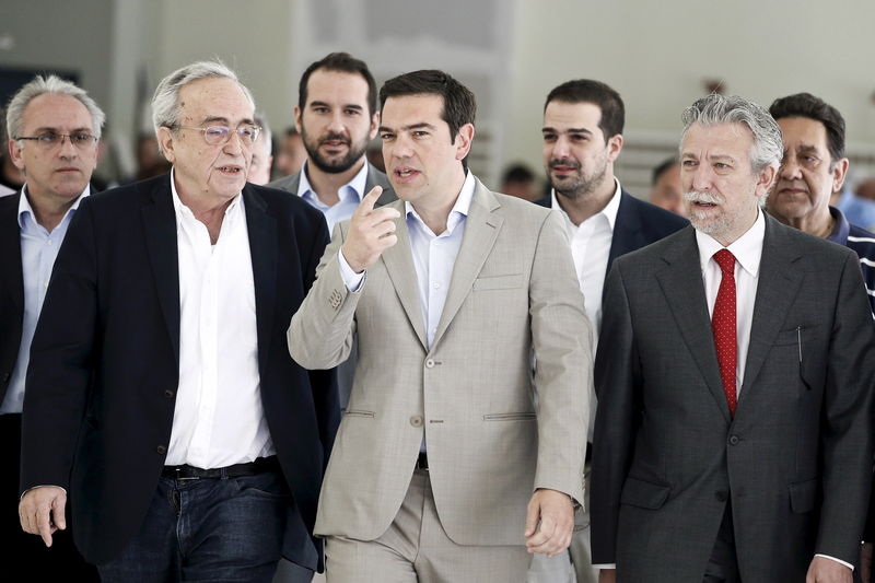 © Reuters. Greek PM Tsipras gestures as he is escorted by Baltas, Kontonis and Sakellaridis during his visit at the ministry in Athens