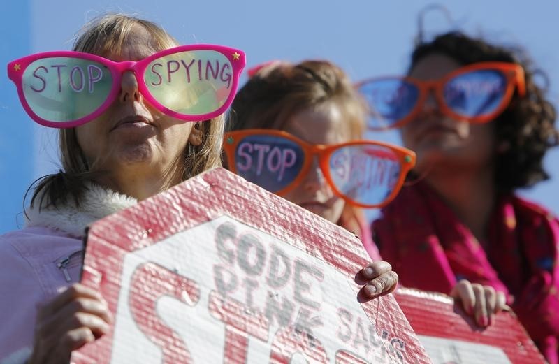 © Reuters. Demonstrators from organization Code Pink wear toy glasses reading "Stop Spying" at "Stop Watching Us: A Rally Against Mass Surveillance" near U.S. Capitol in Washington