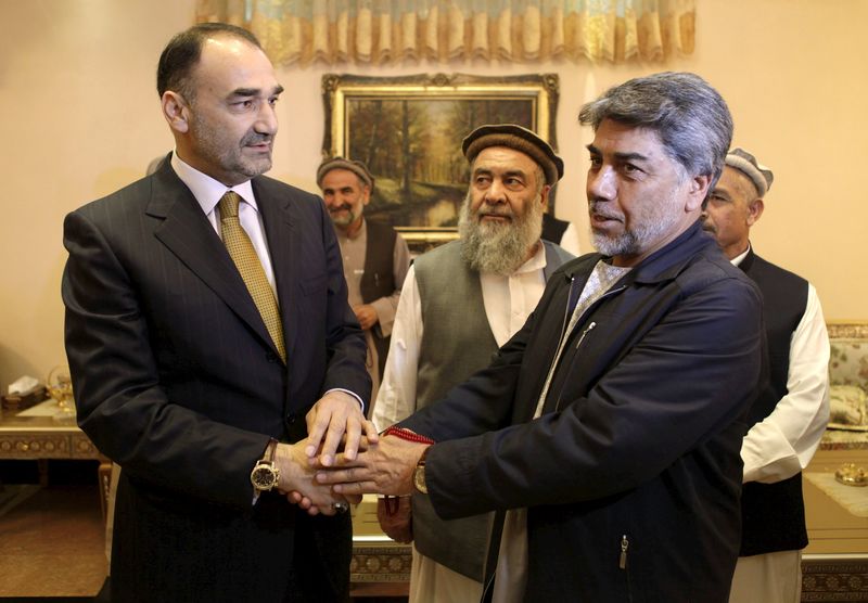 © Reuters. Governor of Mazar-i-Sharif Atta Mohammad Noor shakes hands with tribe elders in Mazar-i-Sharif