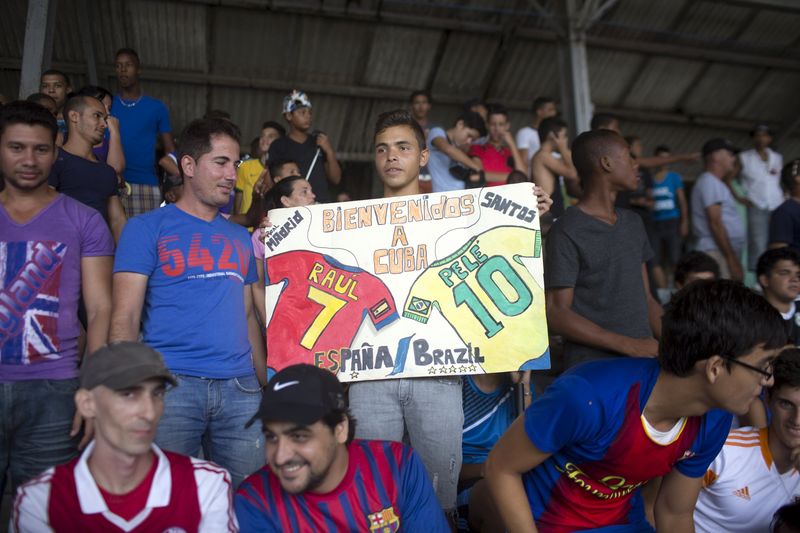 © Reuters. A boy holds a sign welcoming former soccer player Pele and New York Cosmos player Raul Gonzalez to Cuba moments before a friendly soccer match in Havana