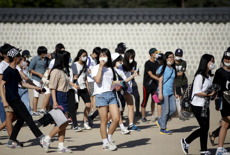 © Reuters. South Korean students wearing masks to prevent contracting MERS walk at the Gyeongbok Palace in central Seoul