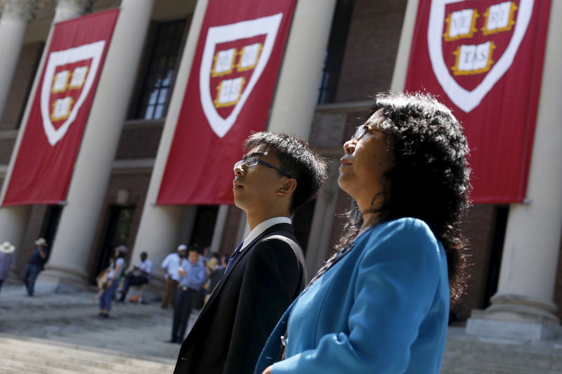 © Reuters. A student and parent pass Widener Library's banners before Harvard University's Class Day Exercises in Cambridge