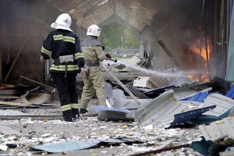 © Reuters. Bombeiros combatem chamas em mercado local atingido por bombardeio em Donetsk