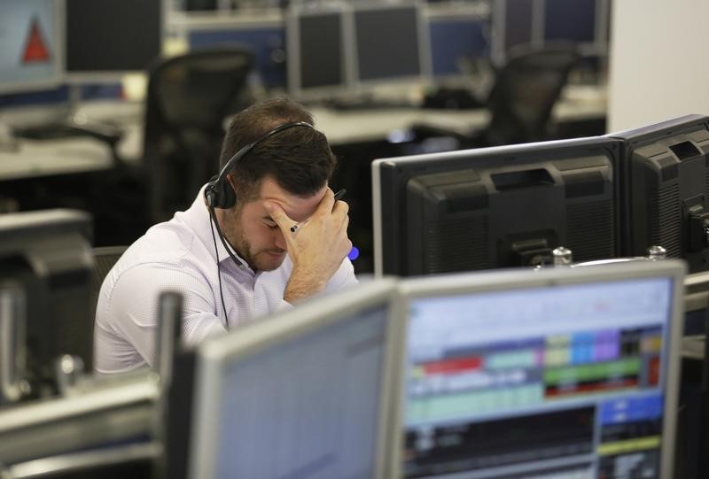 © Reuters. Un trader alla propria postazione di lavoro all'IG Index di Londra