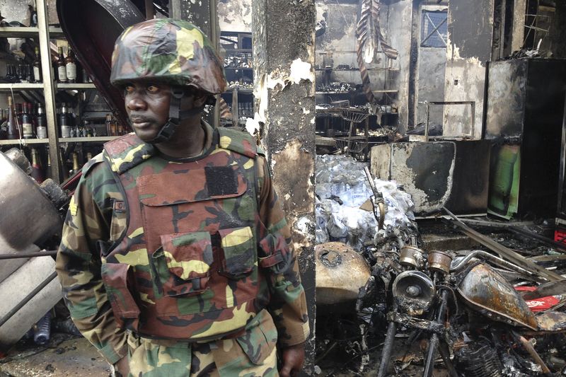 © Reuters. A soldier stands guard at the wreckage of a petrol station that exploded overnight killing around 90 people in Accra