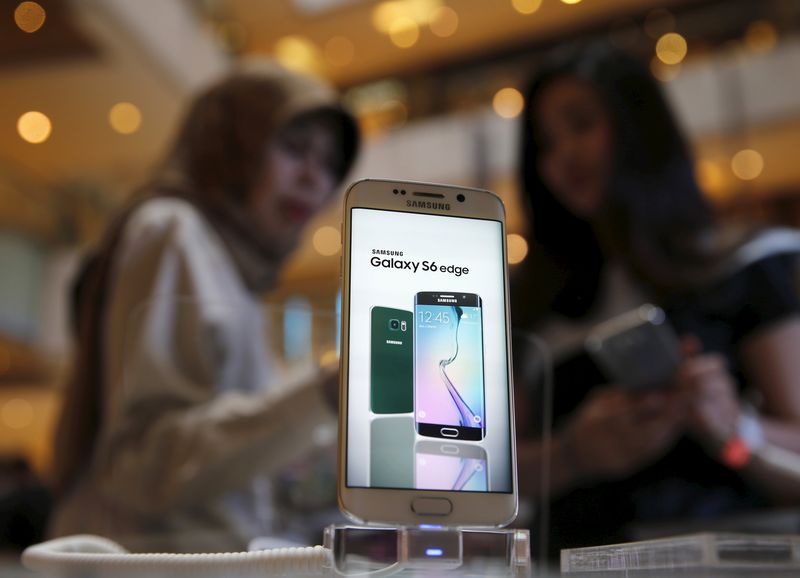 © Reuters. A Samsung Galaxy S6 edge is pictured while a salesperson talks to a customer at the Grand Indonesia mall in Jakarta