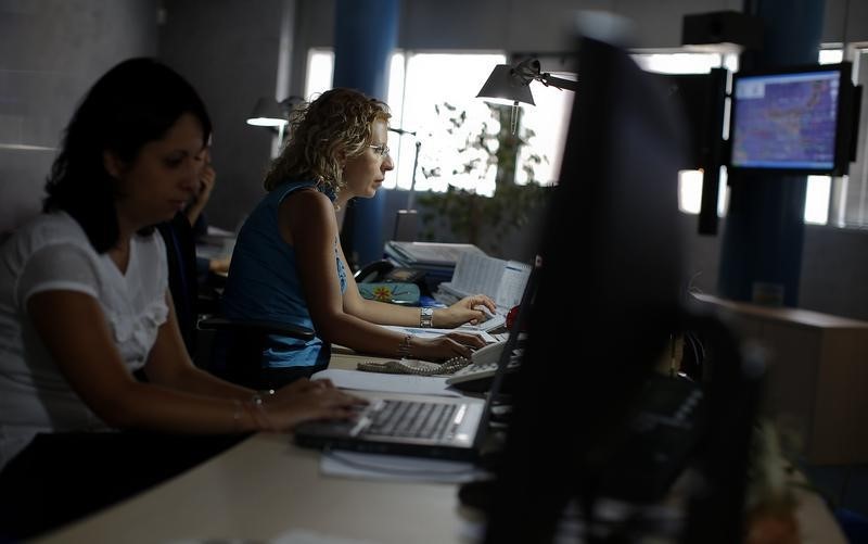 © Reuters. Members of the customs agency's anti-fraud unit work in their office hi-tech nerve centre on the outskirts of Rome