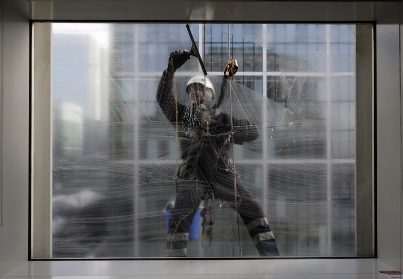 © Reuters. A window cleaner works on a building in the financial district of Canary Wharf in London