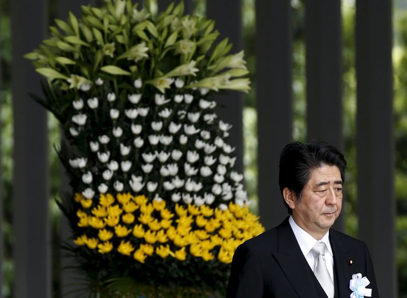 © Reuters. Japan's PM Abe walks after offering a flower for Japan's unidentified war dead, during a ceremony at Chidorigafuchi National Cemetery in Tokyo