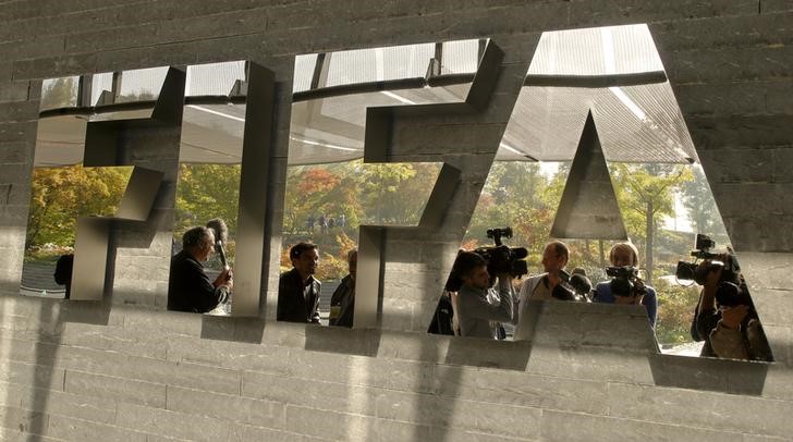 © Reuters. Journalists are reflected in a logo at the FIFA headquarters in Zurich