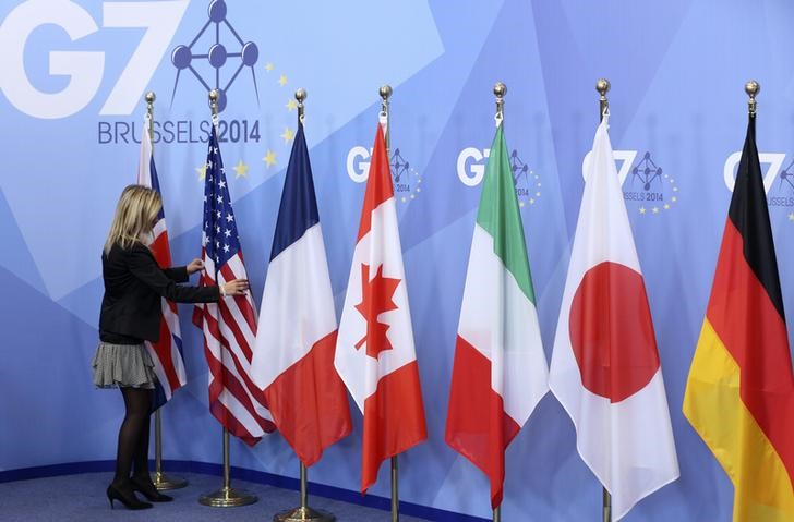 © Reuters. Funcionária ajeita bandeiras durante cúpula do G7, em Bruxelas