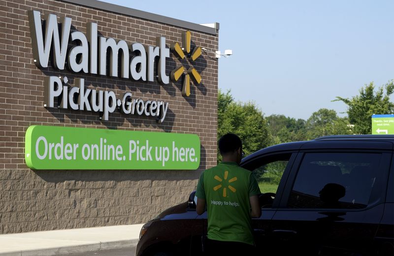 © Reuters. A Wal-Mart Pickup-Grocery employee helps a customer at a test store in Bentonville