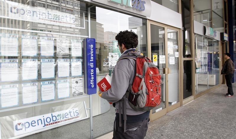 © Reuters. A man checks job offers outside a recruitment agency in downtown Milan