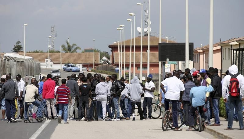 © Reuters. Migrants gather at an immigration center in Mineo, on the Italian island of Sicily