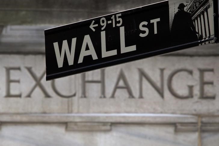 © Reuters. A Wall Street sign is pictured in front of the New York Stock Exchange, open during Winter Storm Juno, in the Manhattan borough of New York