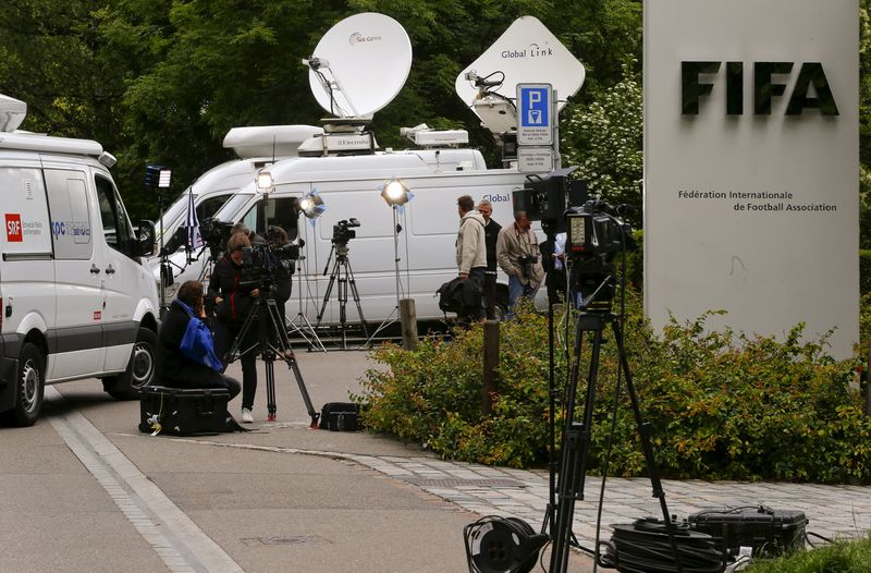 © Reuters. Members of the media stand in front of the entrance of the FIFA headquarters in Zurich