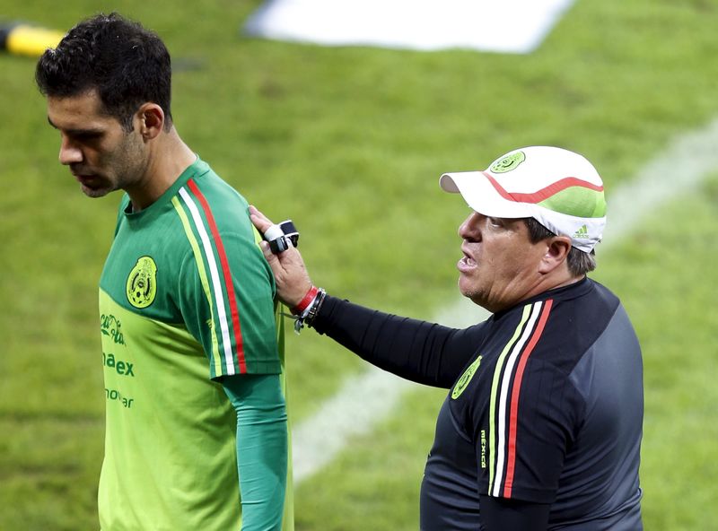 © Reuters. Head coach of Mexico's soccer team Herrera talks to Marquez during their training session in Sao Paulo