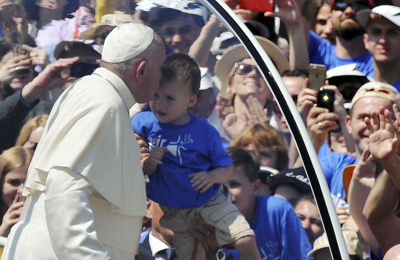 © Reuters. Pope Francis kisses a child as he leaves the stadium in his Papamobile after celebrating a Holy Mass in Sarajavo