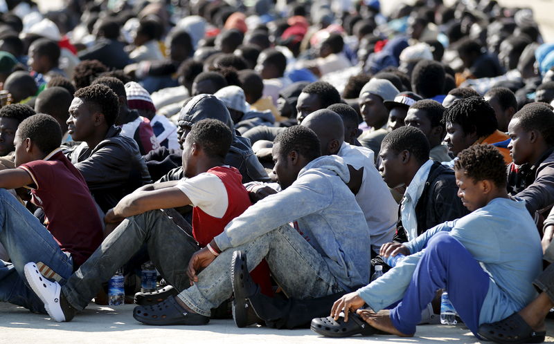 © Reuters. Migrants rest after disembarking from Coast Guard vessel Peluso in the Sicilian harbour of Augusta