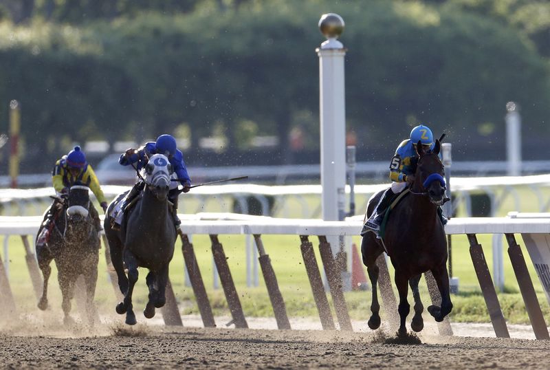 © Reuters. American Pharoah, with jockey Victor Espinoza, leads the pack en route to winning the 147th running of the Belmont Stakes as well as the Triple Crown, in Elmont