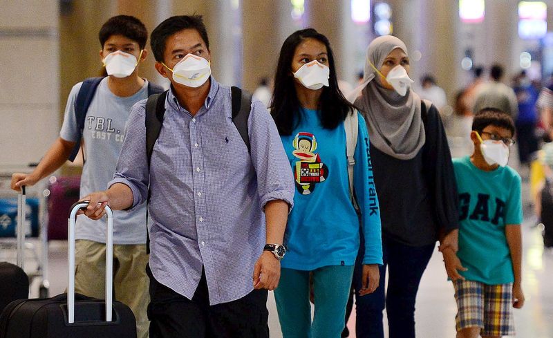 © Reuters. Tourists wearing masks to prevent themselves from contracting Middle East Respiratory Syndrome (MERS) arrive at the Incheon International Airport in Incheon