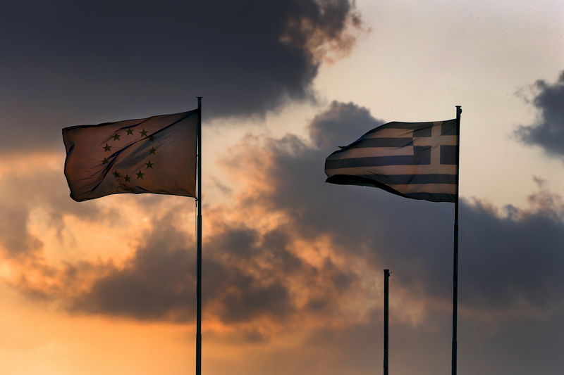 © Reuters. An EU flag flatters next to a Greek flag atop the Ministry of Finance during sunset in Athens, Greece 