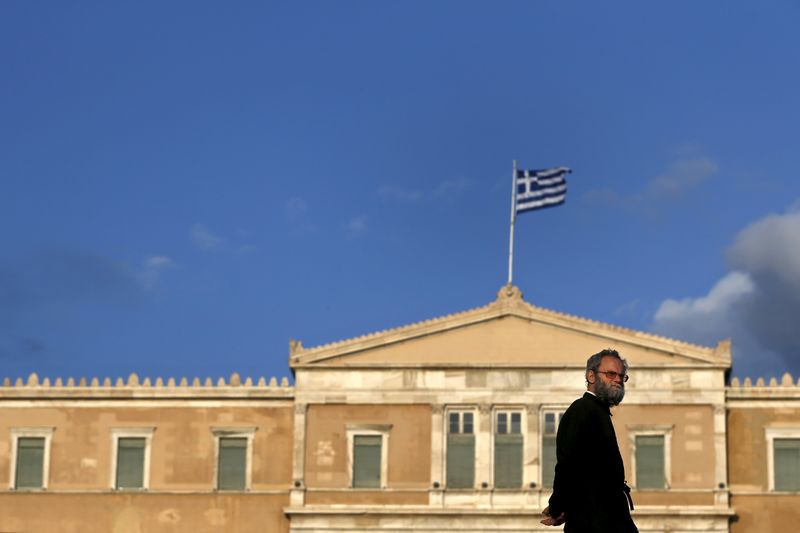 © Reuters. Orthodox priest walks in front of the parliament building in Athens 