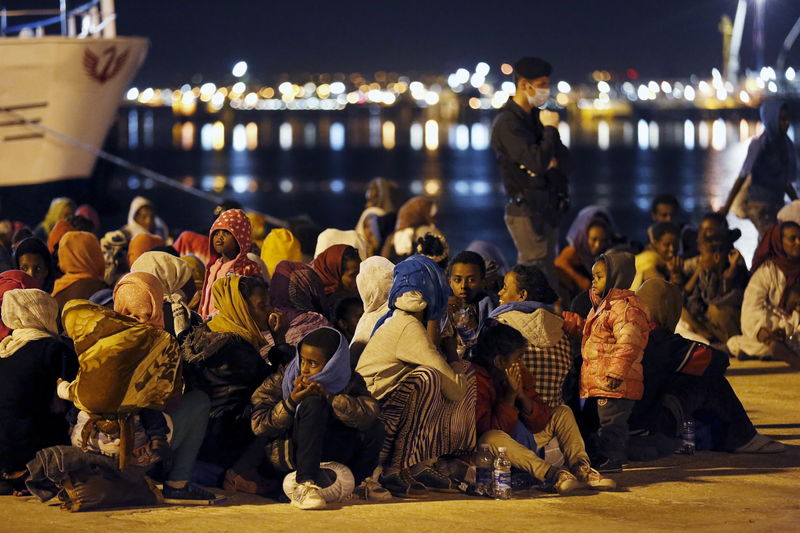 © Reuters. Migrants rest after disembarking from the expedition vessel Phoenix in the Sicilian harbour of Augusta