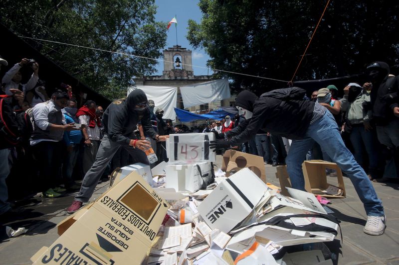 © Reuters. Membros do sindicato de professores CNTE se preparam para queimar material eleitoral em Oaxaca