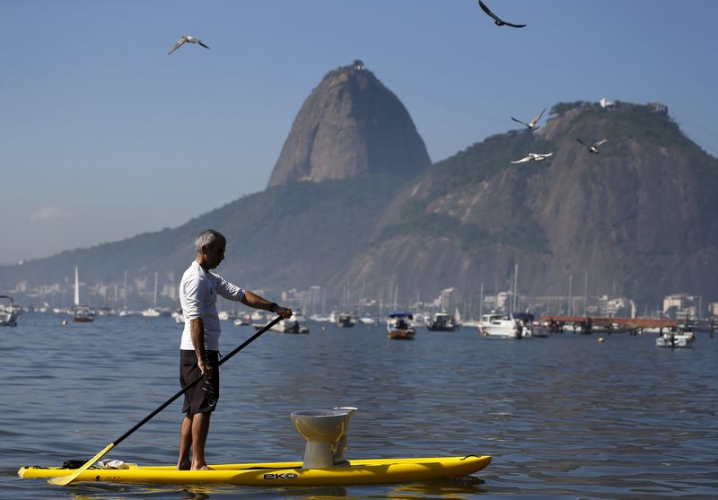 © Reuters. Homem com latrina na Baía de Guanabara durante protesto no Rio de Janeiro