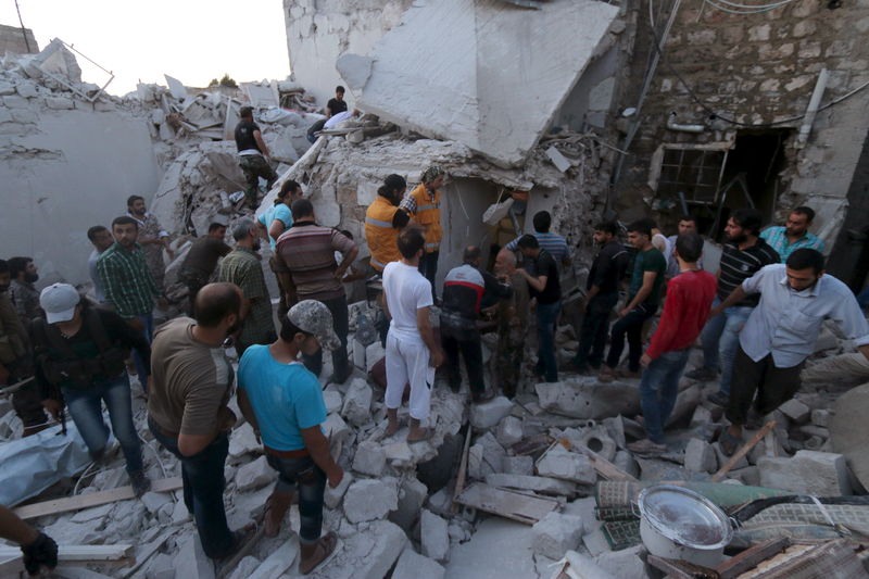 © Reuters. Moradores procuram sobreviventes em local supostamente atingido por bombas de barril