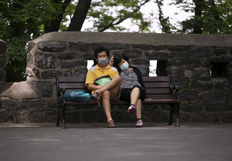 © Reuters. Casal usa máscaras para se proteger da Mers em Seul