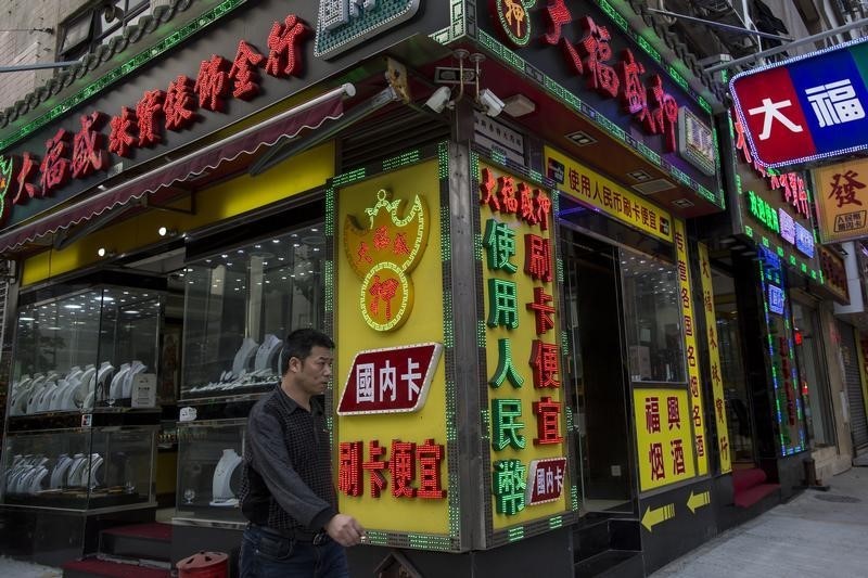 © Reuters. Un uomo davanti ad un negozio a Macao 