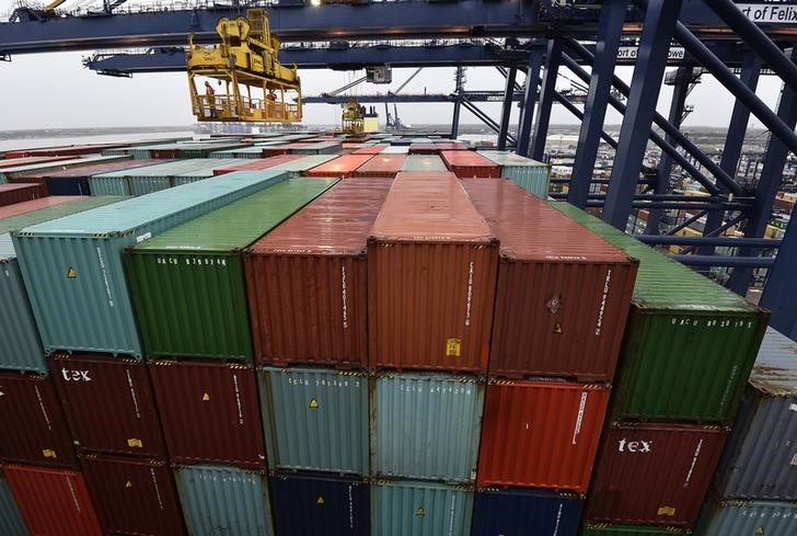 © Reuters. Port workers inspect containers as largest container ship in world, CSCL Globe, docks during maiden voyage, at the port of Felixstowe in south east England.