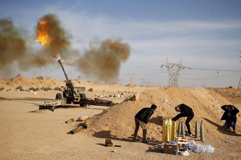 © Reuters. Libya Dawn fighters fire an artillery cannon at IS militants near Sirte