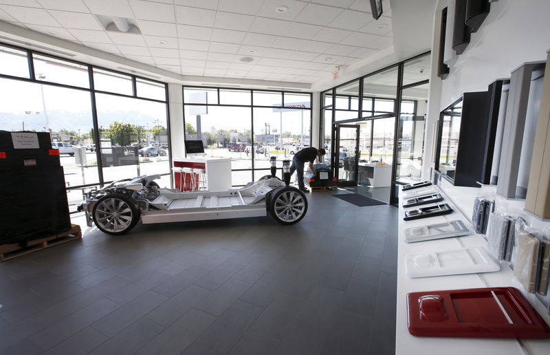 © Reuters. An employee sets up a display at an showroom at a new Tesla dealership in Salt Lake City 