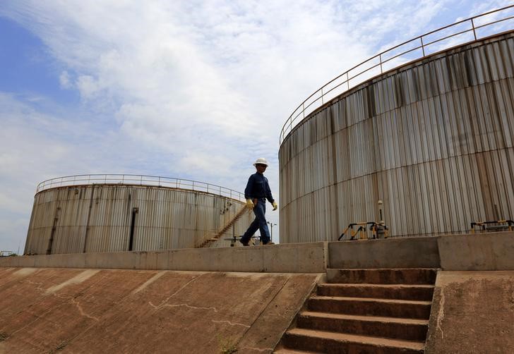 © Reuters. Рабочий Pacific Rubiales Petroleum Company у резервуаров для хранения нефти на месторождении в Колумбии