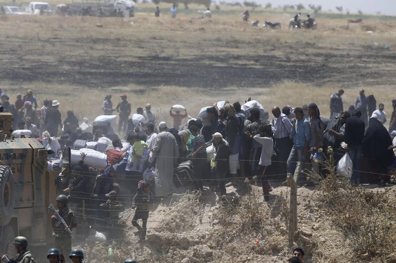 © Reuters. Miles de personas huyen de Siria a Turquía en medio de combates entre kurdos y el EI